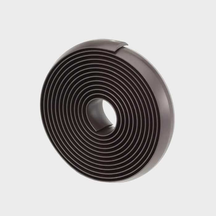 Coiled, layered strip sits upright in a circular form against a plain, light gray background.