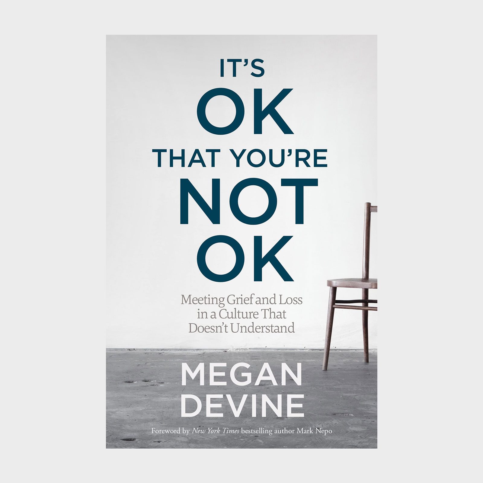 Book cover reads, "IT'S OK THAT YOU'RE NOT OK" by Megan Devine. Features a chair on a gray floor background.