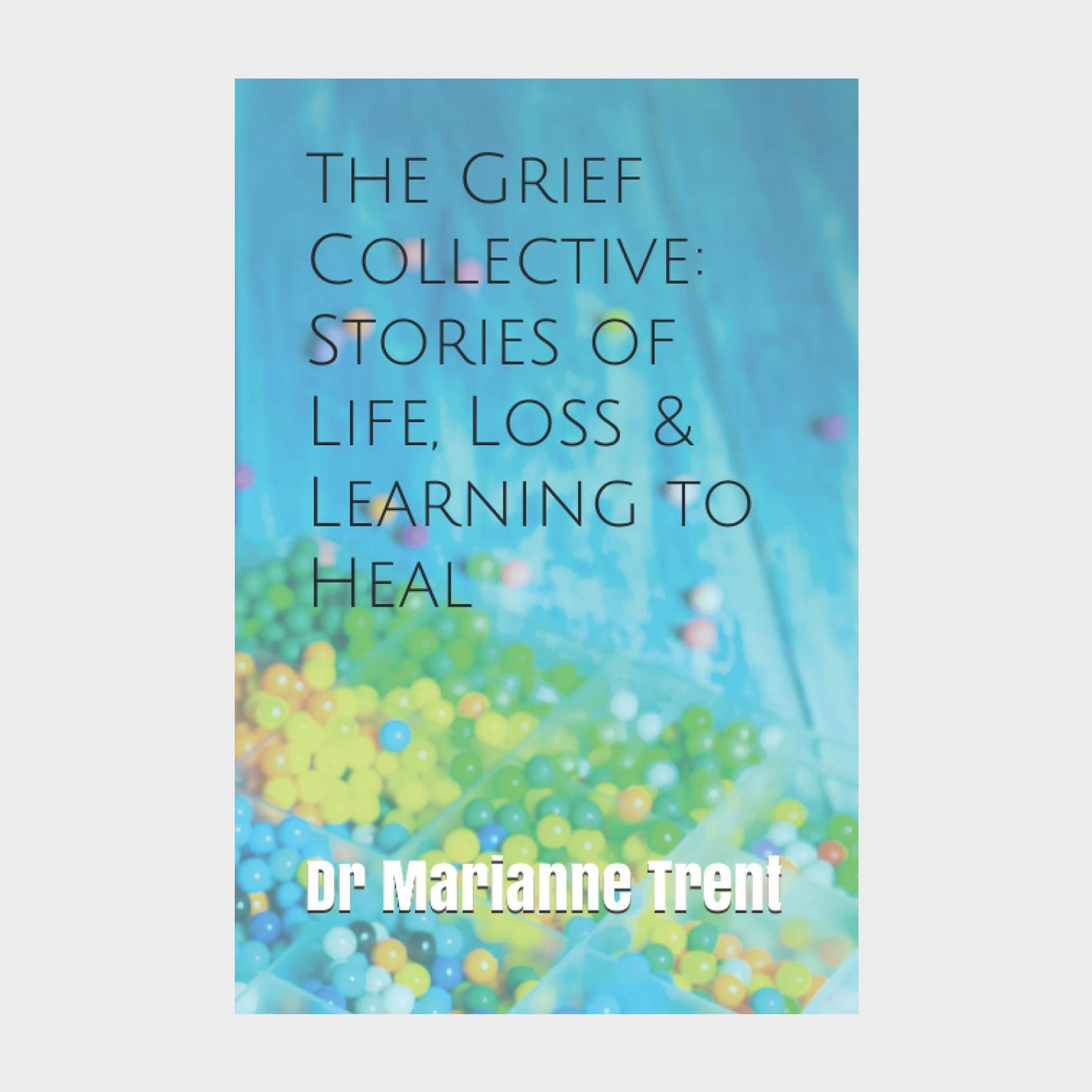 Book cover features colorful beads on a blue surface with text: "The Grief Collective: Stories of Life, Loss & Learning to Heal - Dr Marianne Trent."
