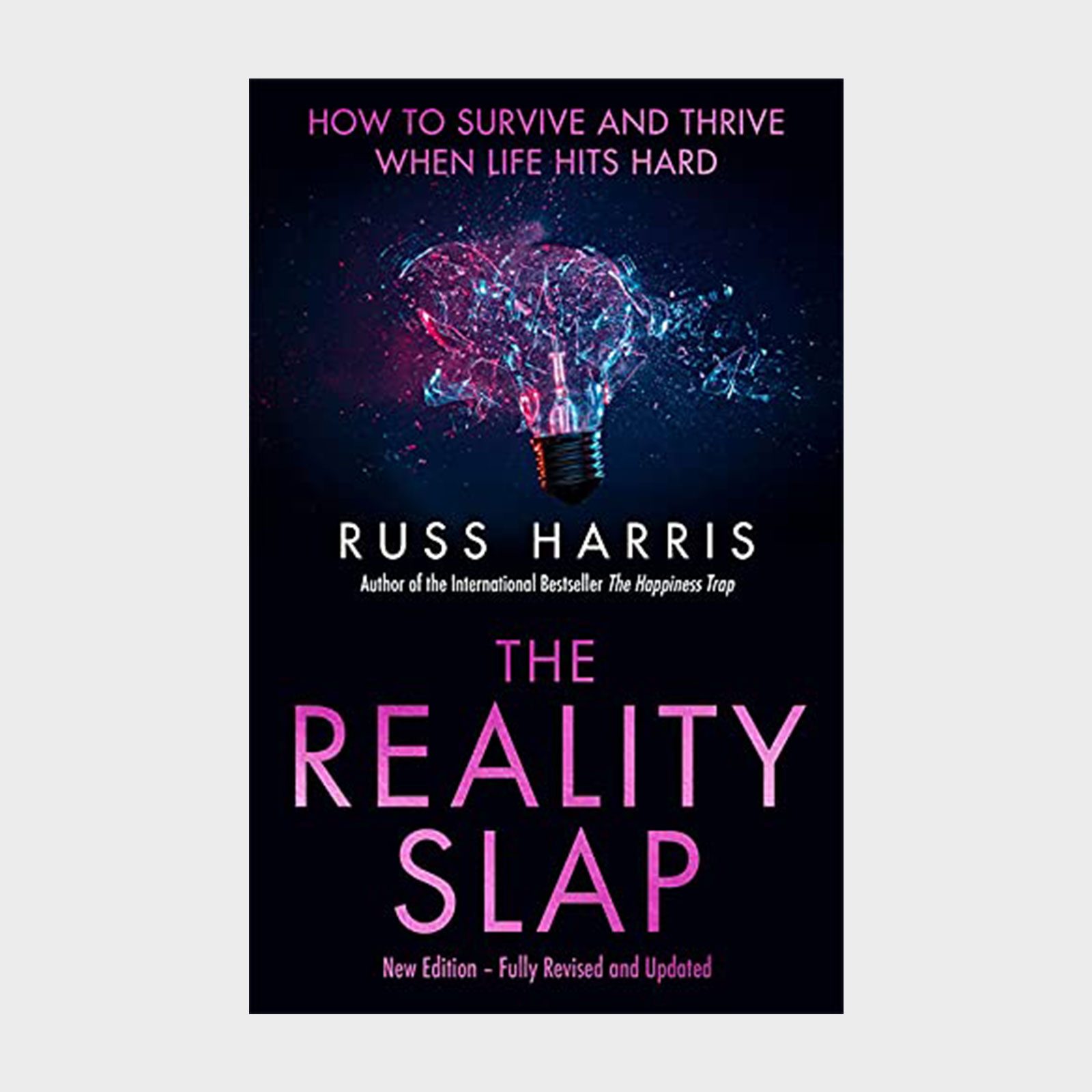A glowing lightbulb shatters, emitting colorful sparks; text reads "The Reality Slap" by Russ Harris, with motivational subtitle context.