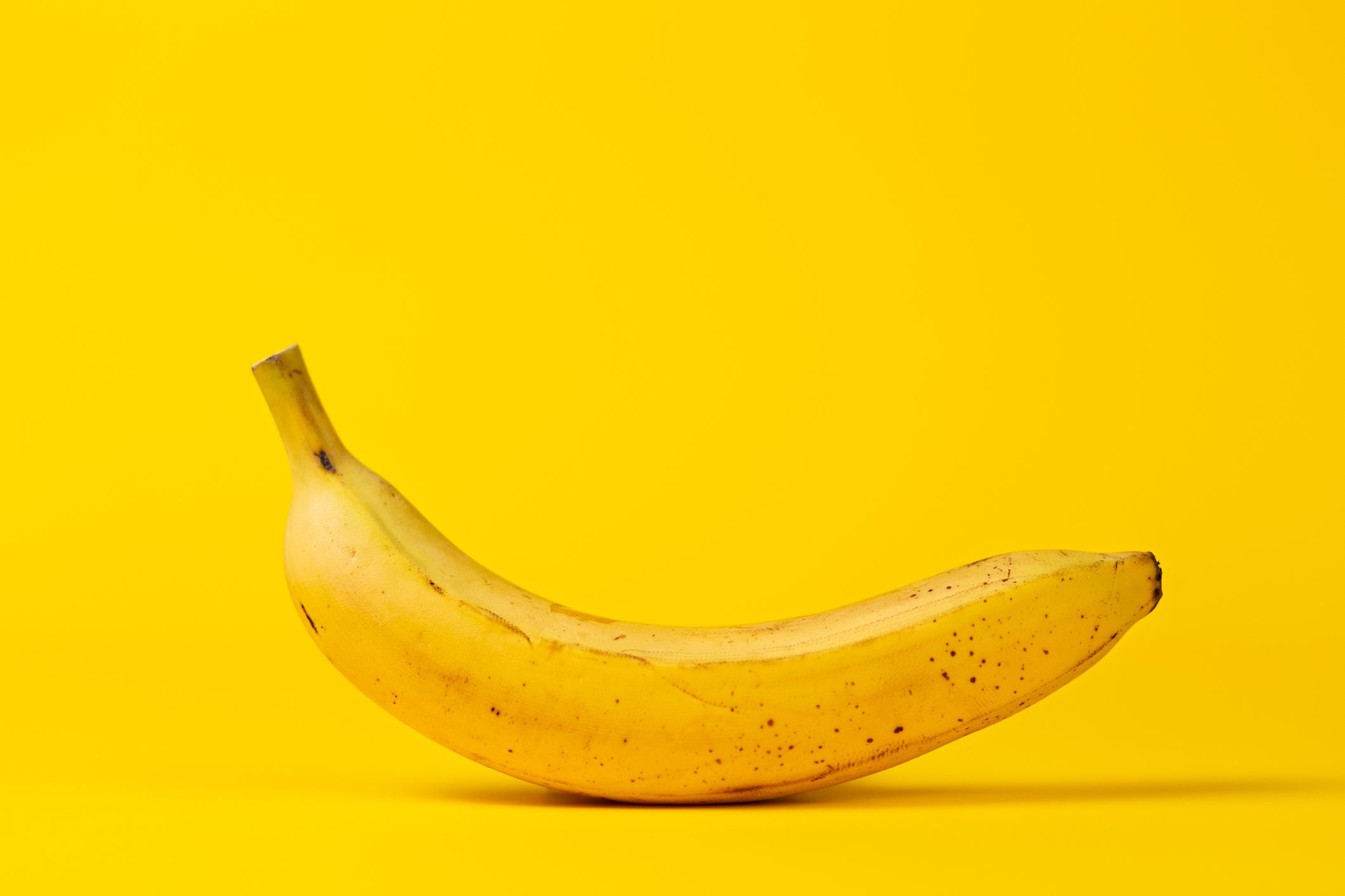 Yellow banana on a yellow background. Copy space