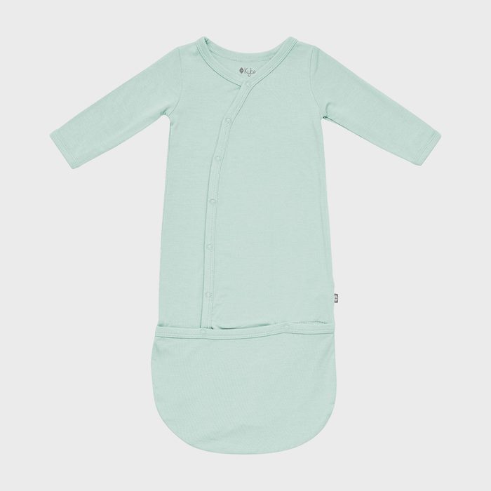 A mint green baby gown lies flat with snap buttons on the front, against a white background.