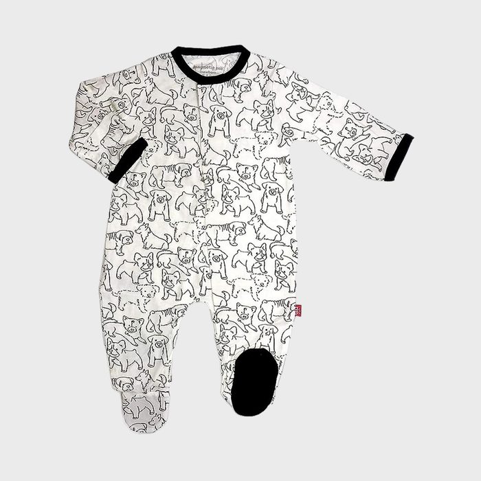 A baby onesie with black dog outlines is laid flat, featuring black cuffs and foot soles, on a plain white background.