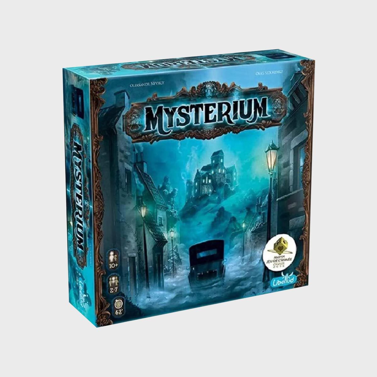 Box displays "Mysterium" game; eerie mansion looms through misty street with vintage car, lamp posts, and blue-toned cityscape. Rated 10+, 2-7 players.