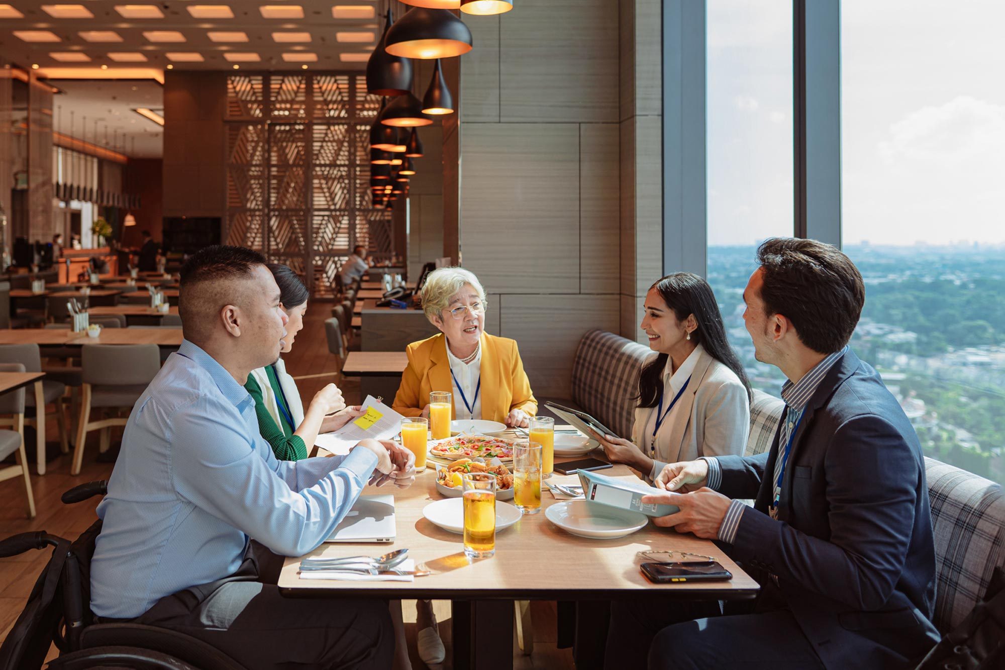 Businesswoman and her diverse team bonding over a meal