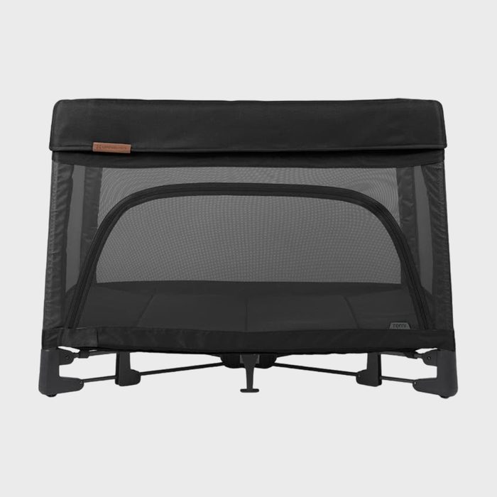 A black mesh playpen stands in a neutral setting. The design is simple, with a visible framework and a flat base.