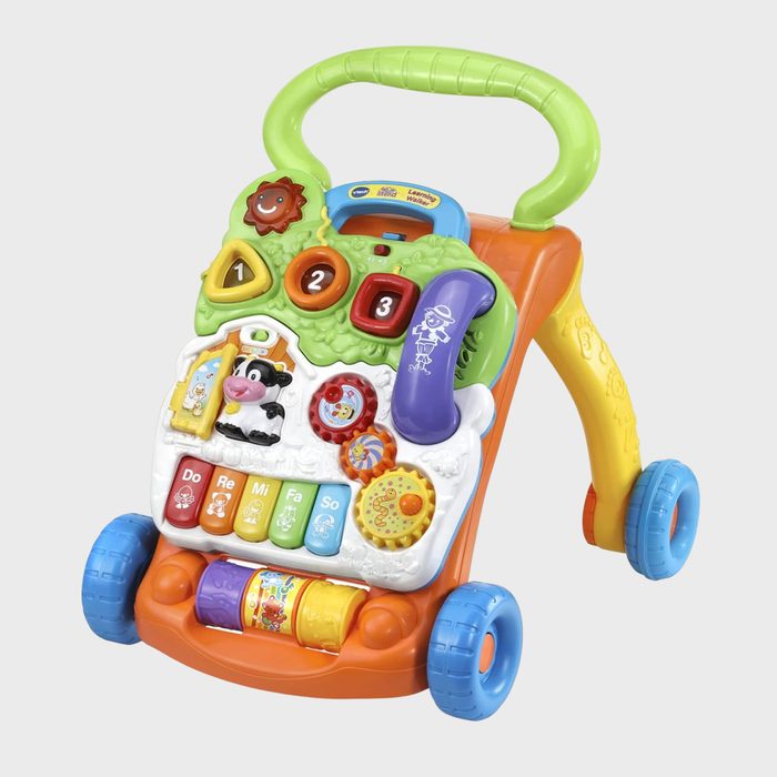 Toy walker displaying colorful buttons and gears; positioned upright with engaging features for interactive play, set against a simple gray background.