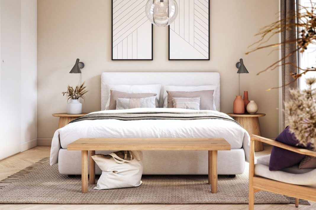 Bed stands neatly in modern bedroom, featuring pillows, wooden bench, side tables, abstract wall art, and warm natural decor.