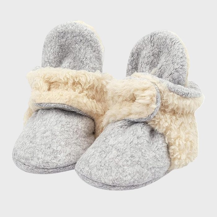 Gray baby booties rest together, featuring soft beige fur lining, set against a plain light gray background.