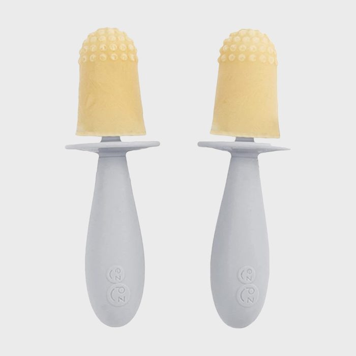 Two gray silicone baby toothbrushes with textured yellow bristles stand upright against a plain white background.
