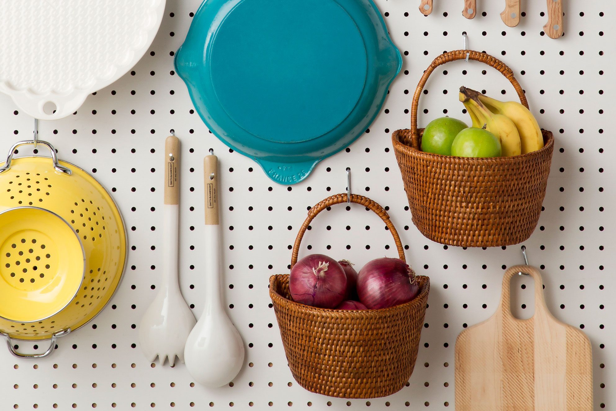 Peg Board Kitchen Organization with pans, utensils, baskets, cutting board hanging
