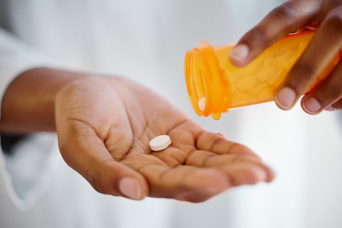 Shot of an unrecognizable person taking tablets at home