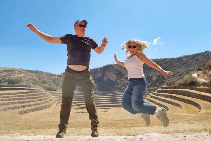 two adults jumping with joy while on vacation with Adventures by Disney