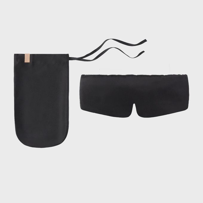 Black sleep mask with ties displayed beside matching pouch on a plain white background.