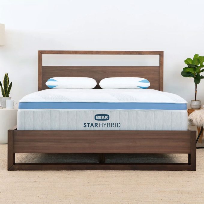 Bed with wooden frame holding mattress labeled 