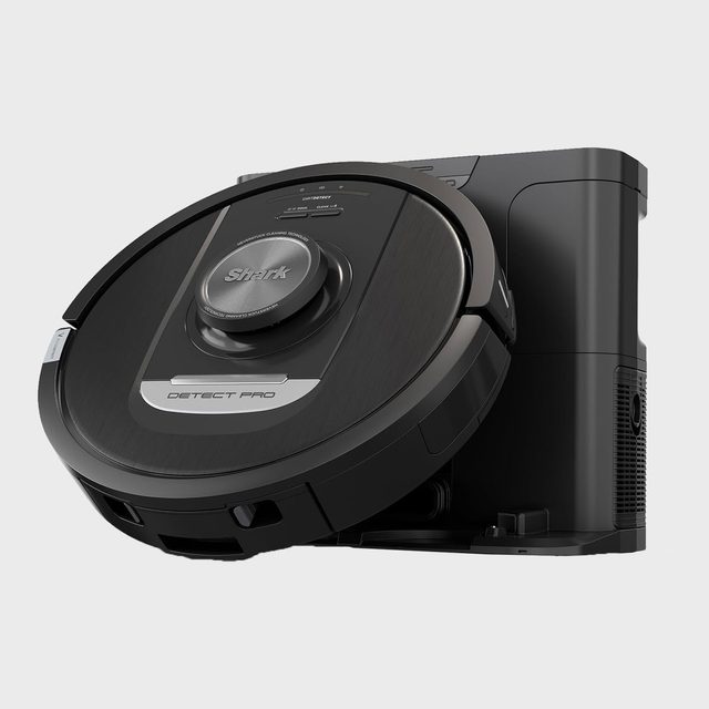 Robot vacuum docks on its black charging station, displaying the label 