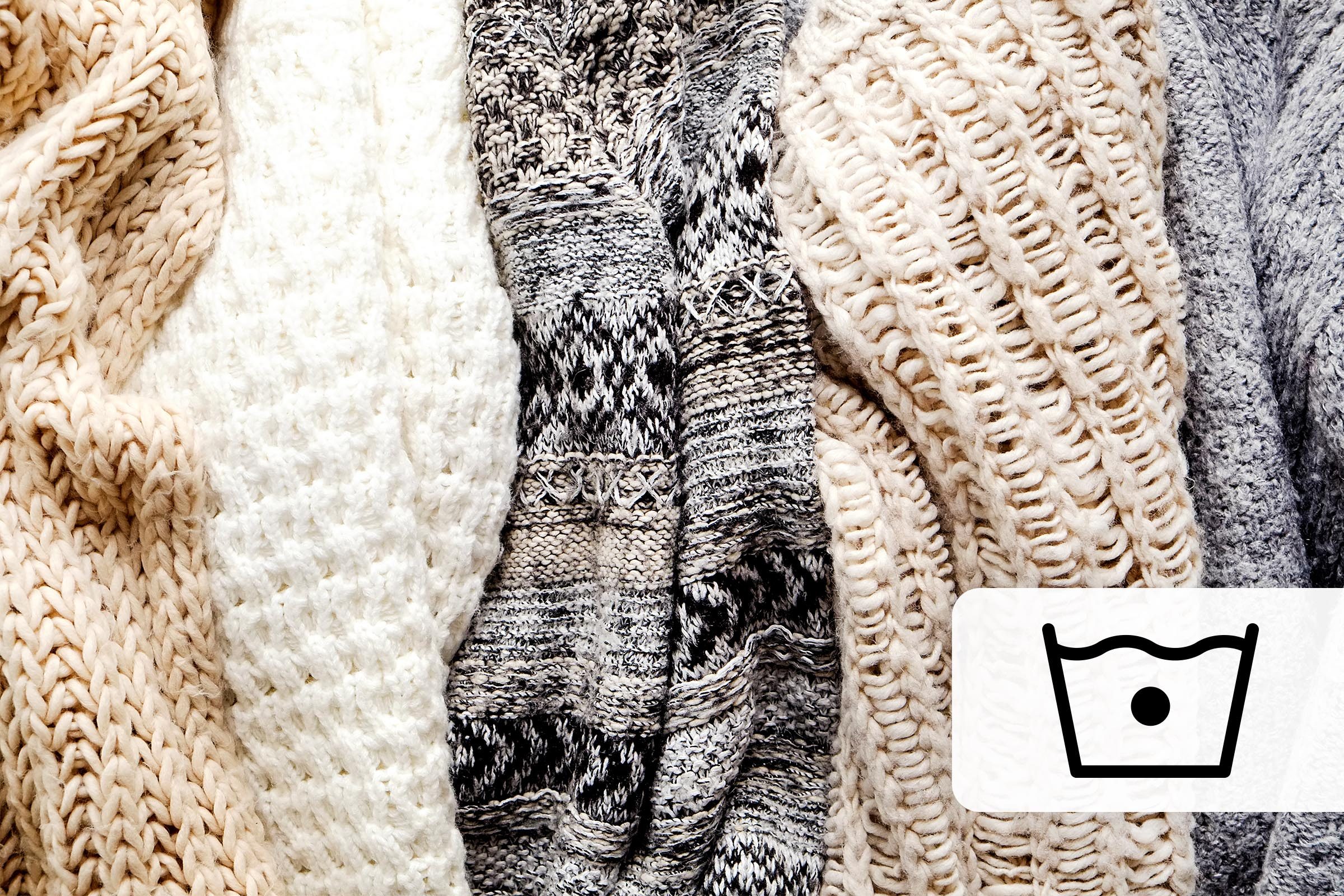 Wool sweaters stacked horizontally with a cold water laundry symbol