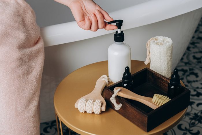 Body skin care after the shower. Bottles of facial, body skin, or hair care products in the bathroom. Home care products for the skin of the face, body and hair. Moisturizing and cleansing the skin, massage brushes.
