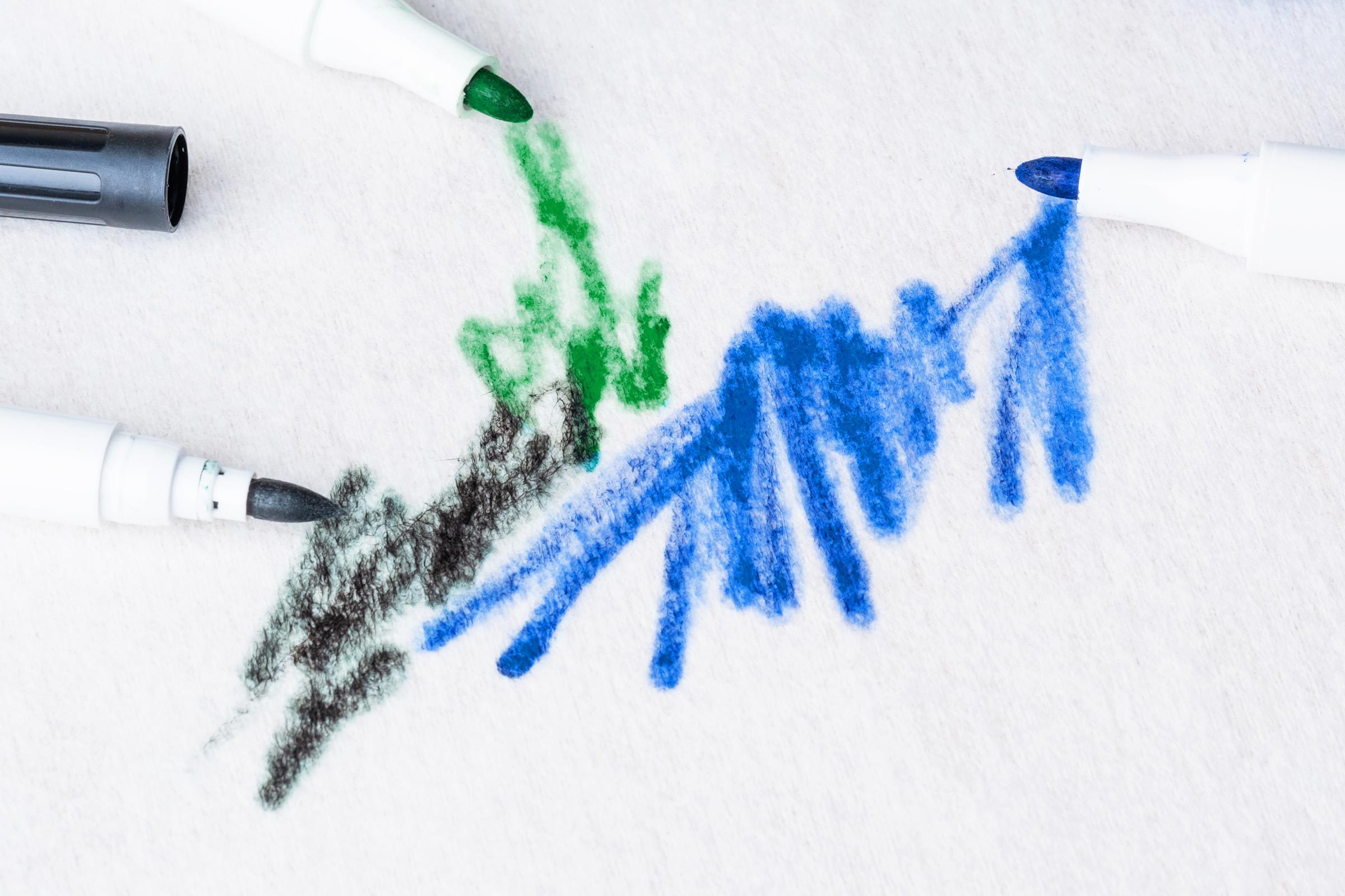 black, green and blue permanent marker scribbles on paper