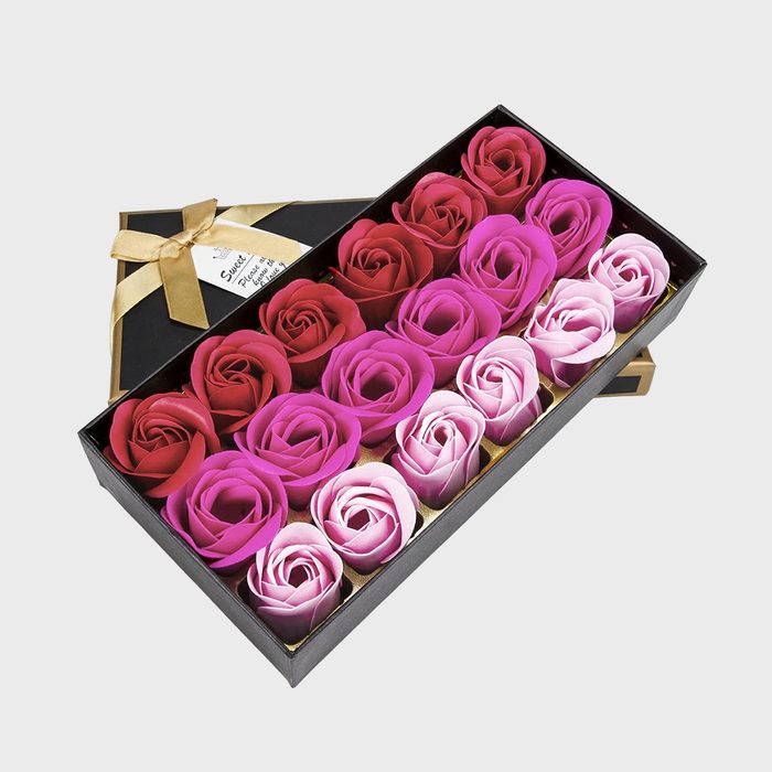 Gift box holds red, pink, and white soap roses, arranged neatly inside a black container with a gold ribbon decoration.