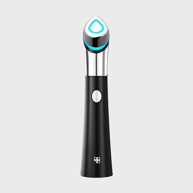 A sleek handheld device with a button and glowing top rests on a white background, possibly a beauty or personal care tool.