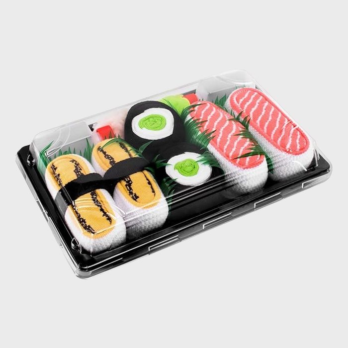 Sushi-shaped socks are arranged inside a clear plastic box, resembling various sushi types, on a light gray background.