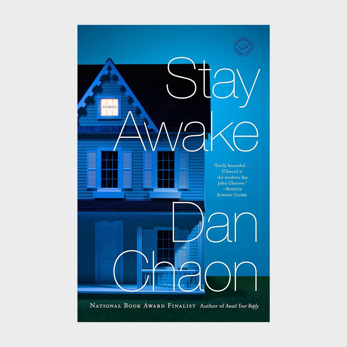 House with blue lighting, window illuminated, title "Stay Awake" and author "Dan Chaon." It's a book cover with a serene, mysterious ambiance.