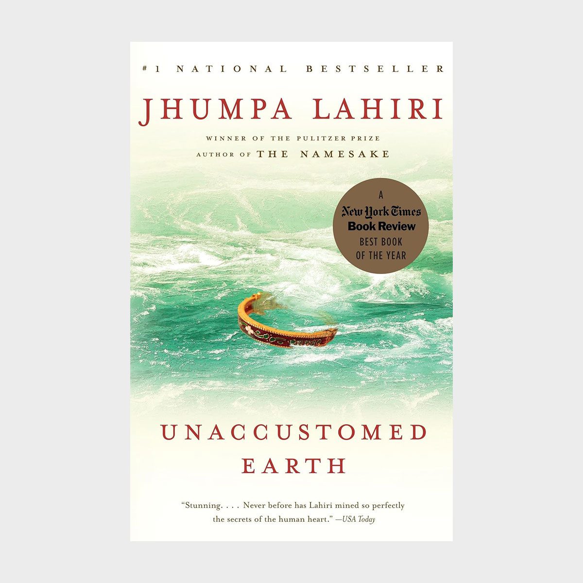 A small boat floats on turbulent green waves; the book cover features title "Unaccustomed Earth" by Jhumpa Lahiri with a New York Times Book Review sticker.