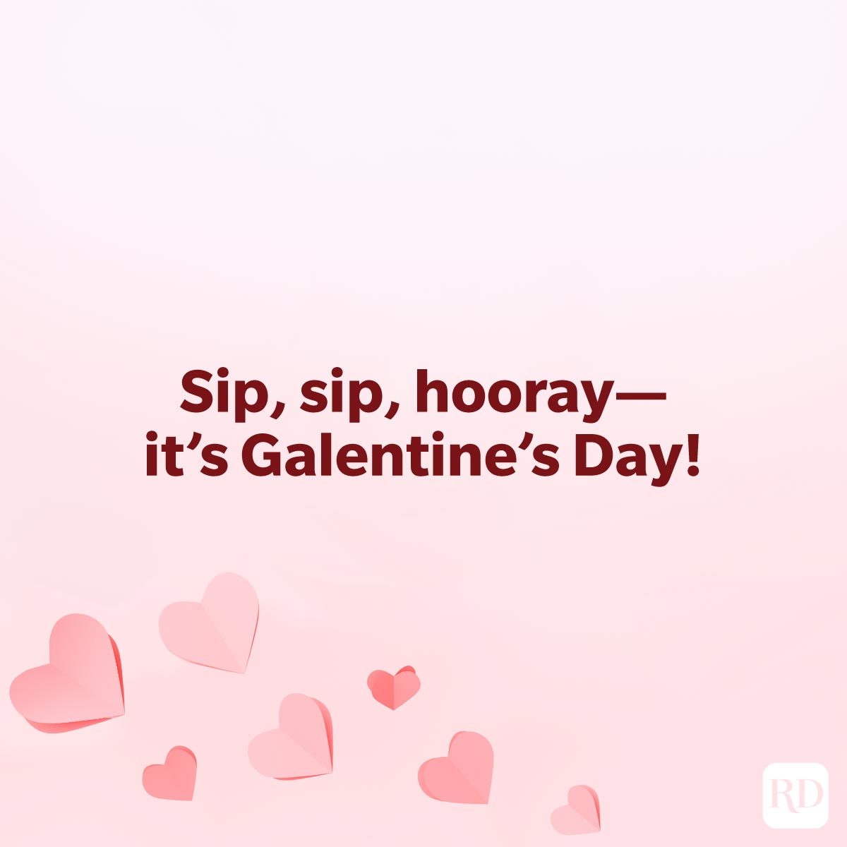 Galentines Day Quotes To Make Your Gal Pals Day quote "Sip, sip, hooray—it's Galentine's Day!" on a pink background with paper origami hearts concentrated on the lower left corner