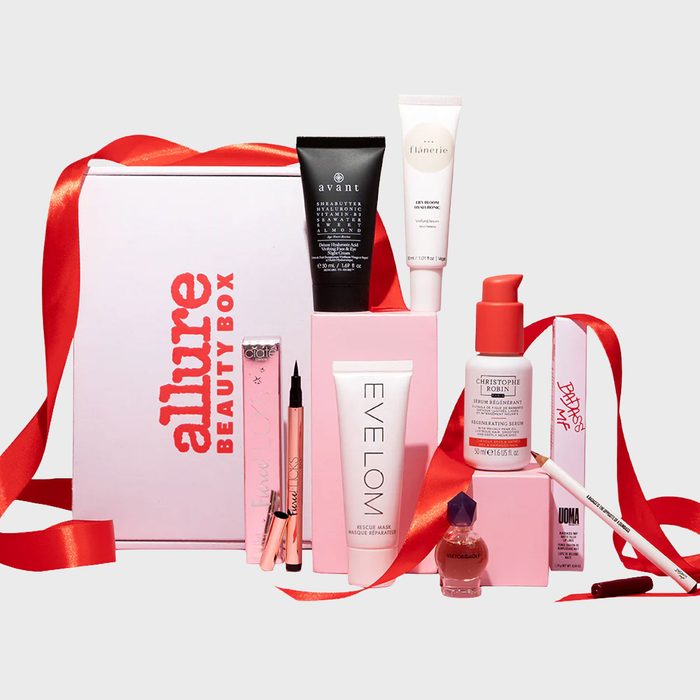 Beauty products displayed around a pink and white 