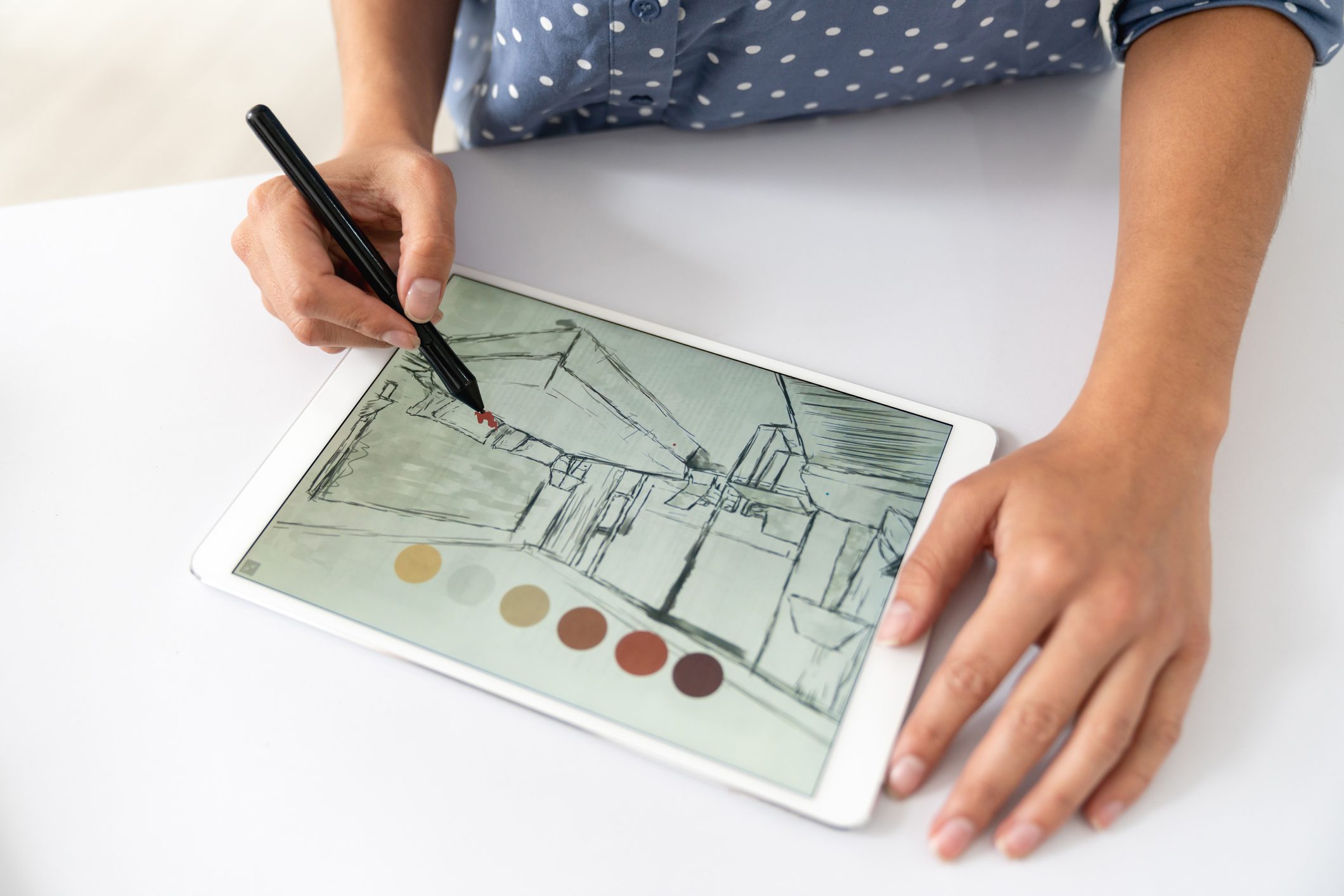 Close-up on an interior designer drawing a sketch on a digital tablet