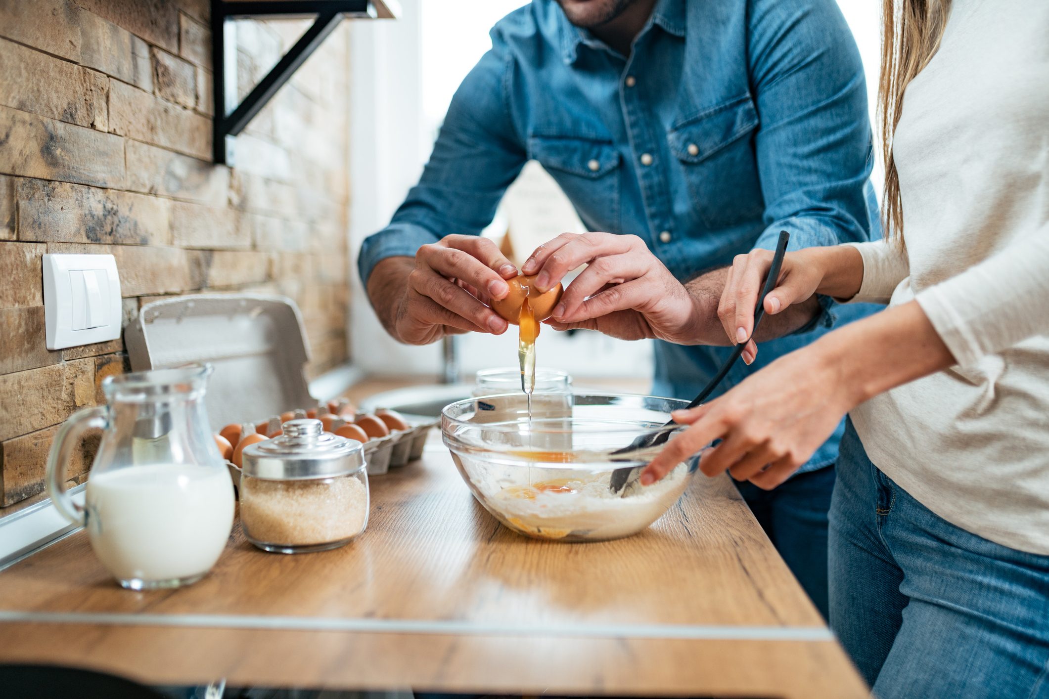 Low angle image of young couple cooking meal together.