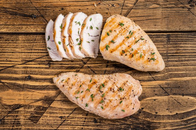 Grilled chicken breast fillet steak. Wooden background. Top view