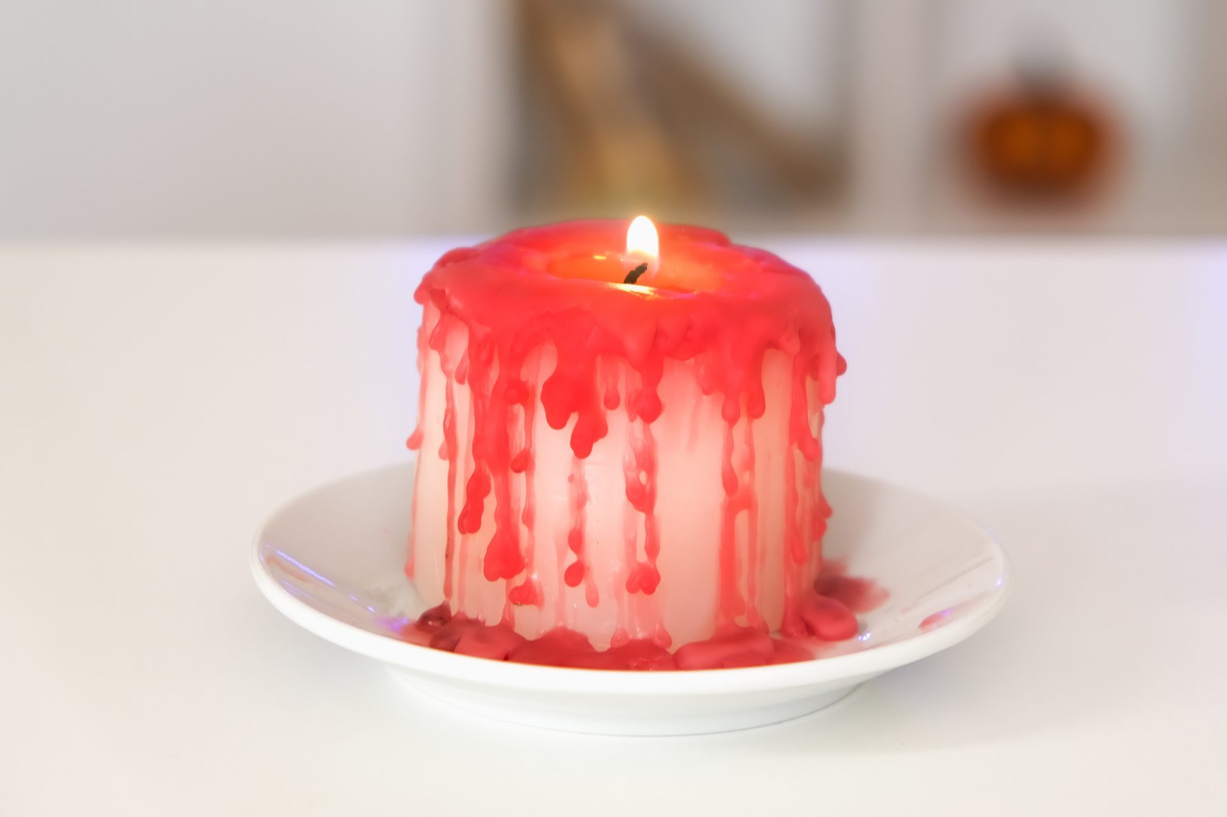 dripping candle onto a glass candle holder plate