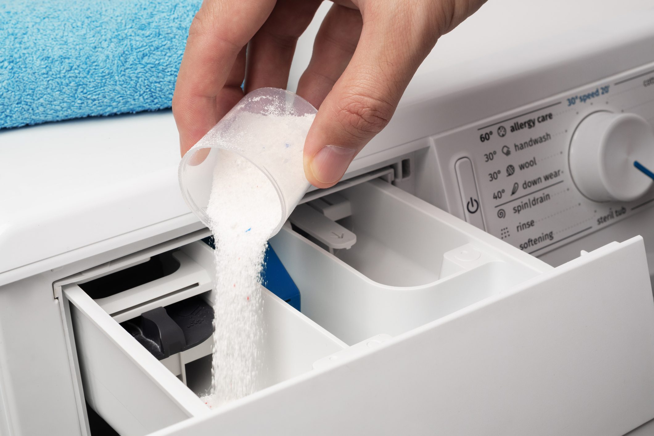 Putting the washing powder in the washing machine. The concept of laundry.