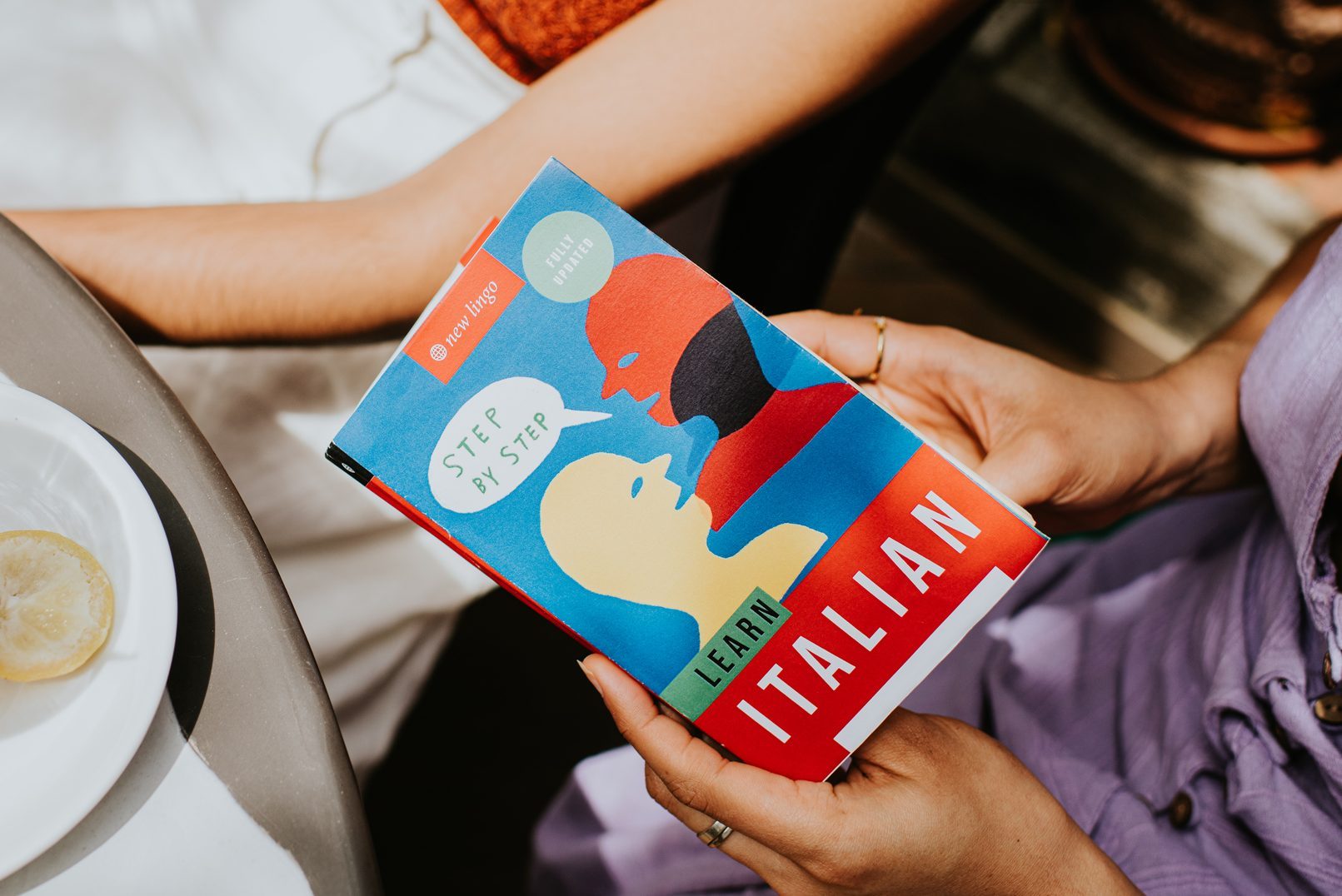 Top down of an English to Italian translation book in the hands of a woman
