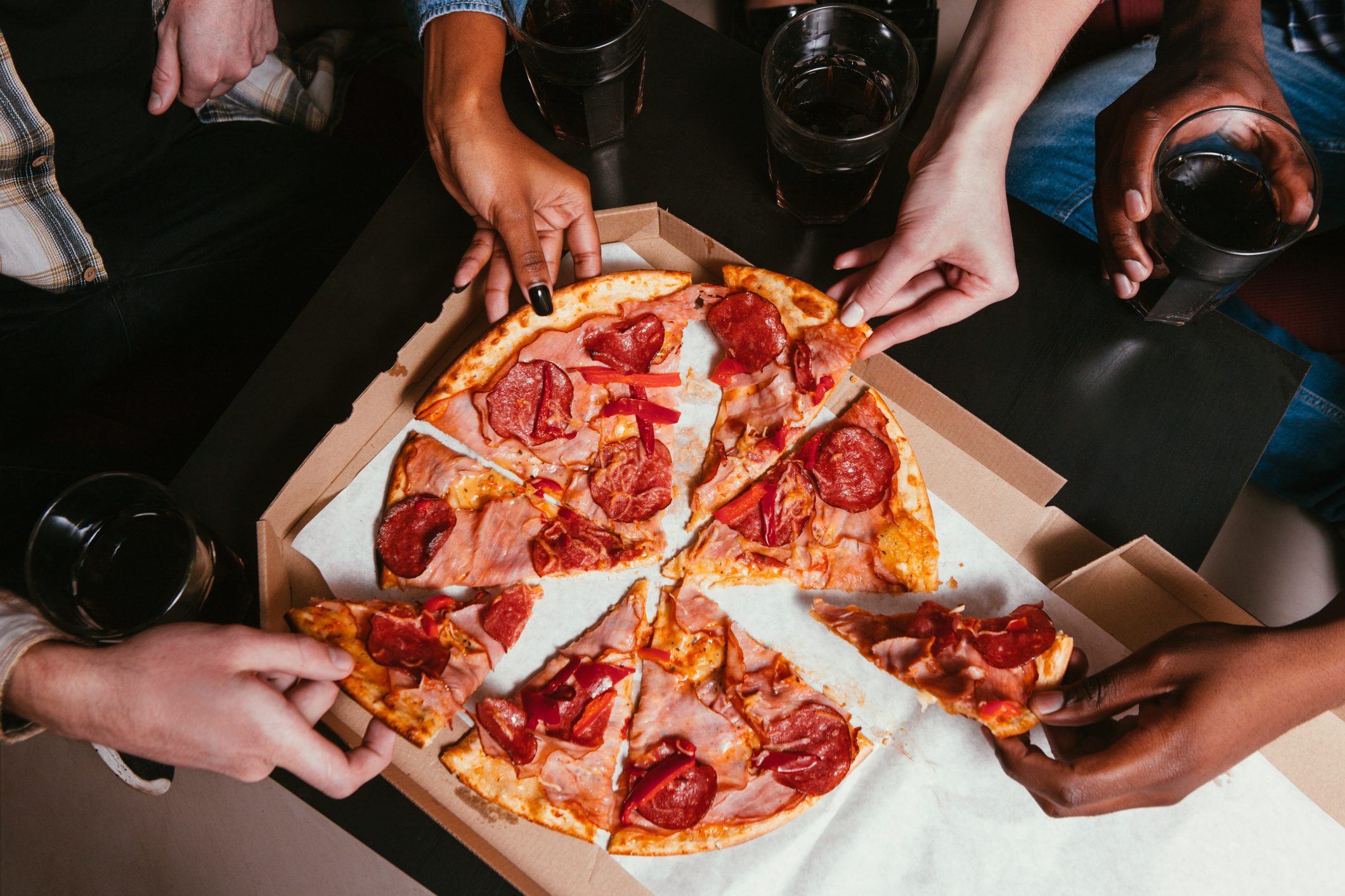 Four friends company eat fresh pizza at home