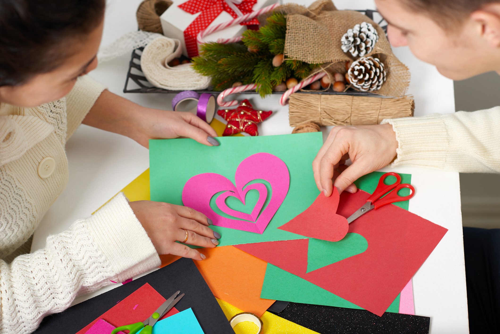 young couple making origami decorations for Valentine day, top view - romantic and love concept