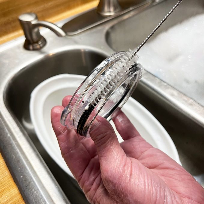 Cleaning the water-bottle lid with a brush