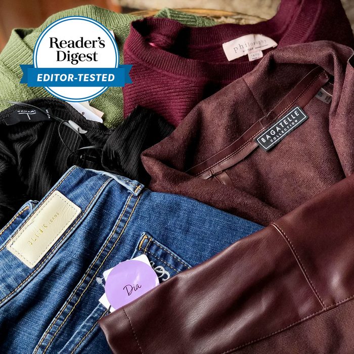 Clothes are neatly arranged, including sweaters and jeans with various brand labels, featuring a 
