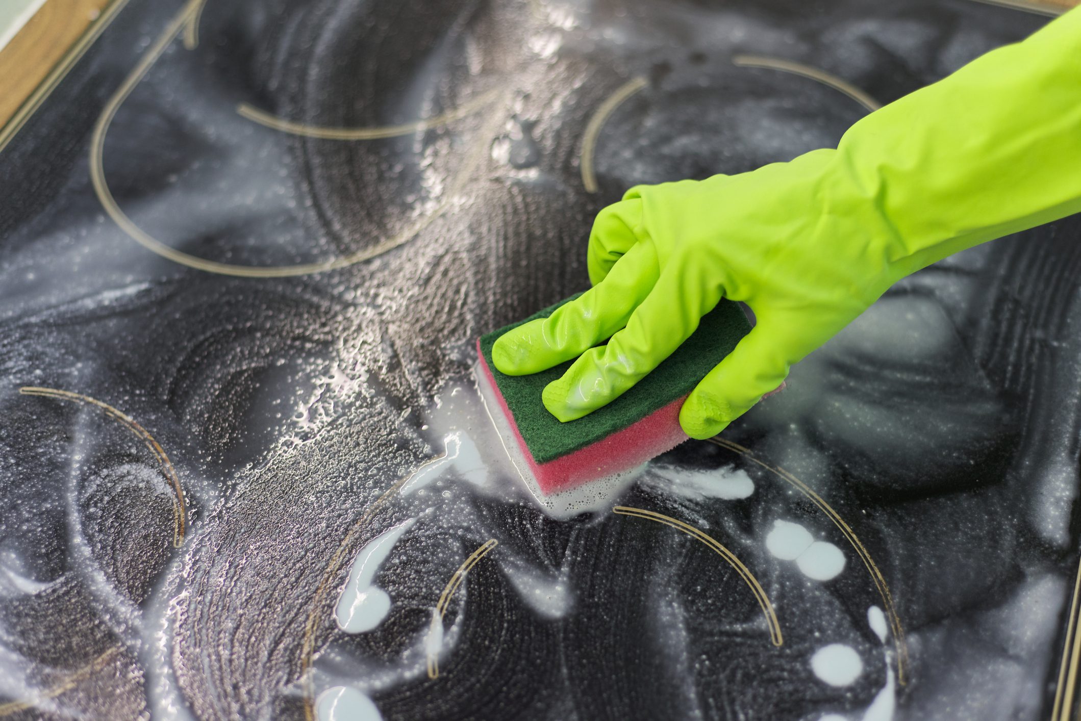 Closeup of hand woman cleaning modern cooking glass