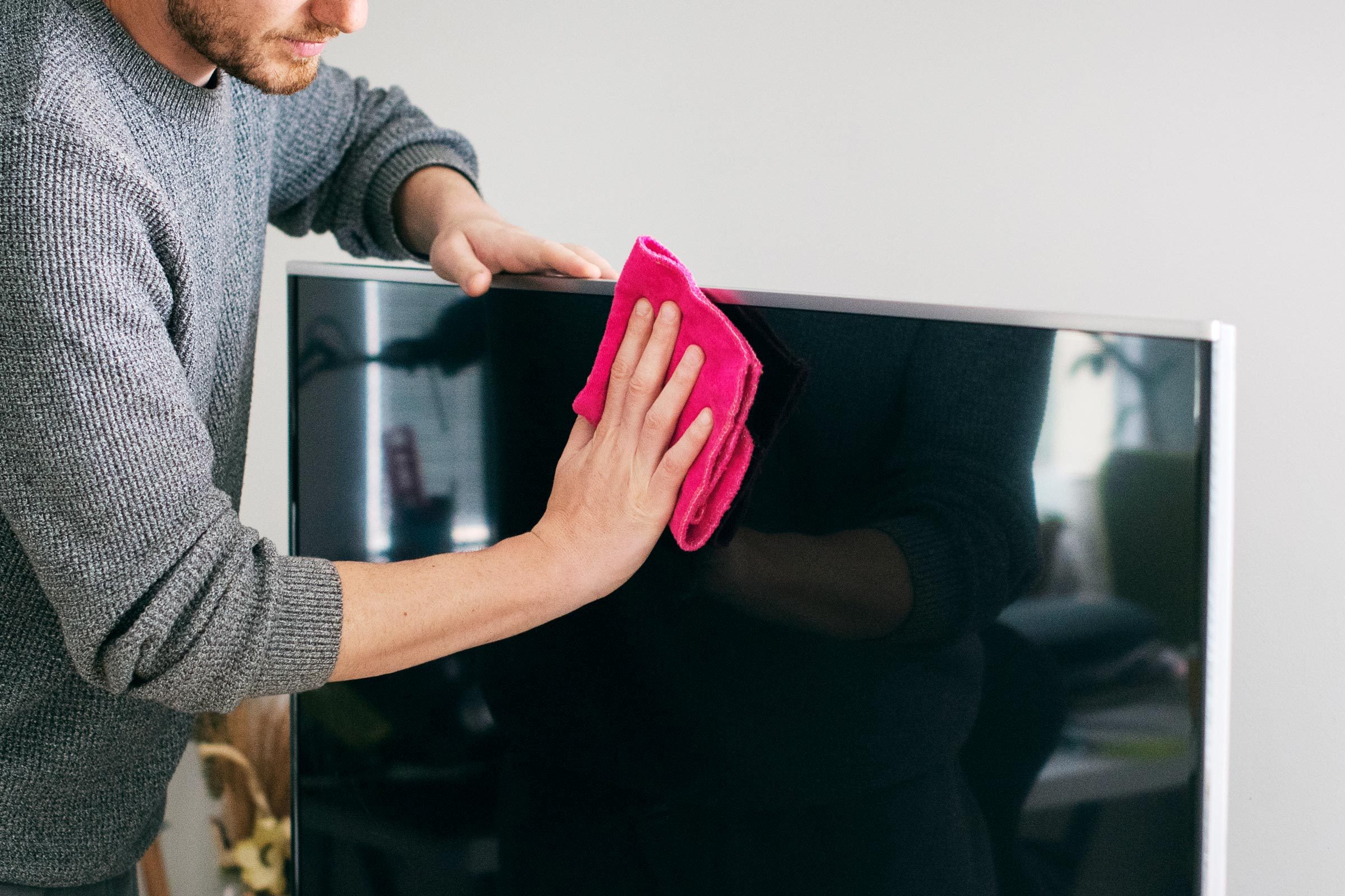 Close up of man cleaning TV screen