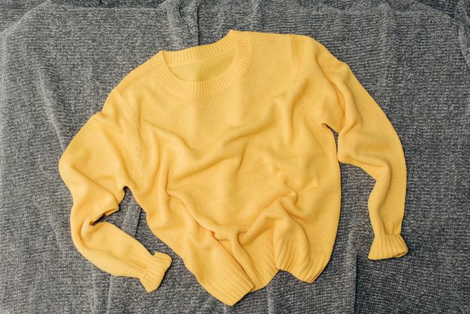 Female orange knitted sweater on white background top view flat lay. Fashion Lady Clothes Set Trendy Cozy Knit Jumper Autumn accessories. Female fashion look