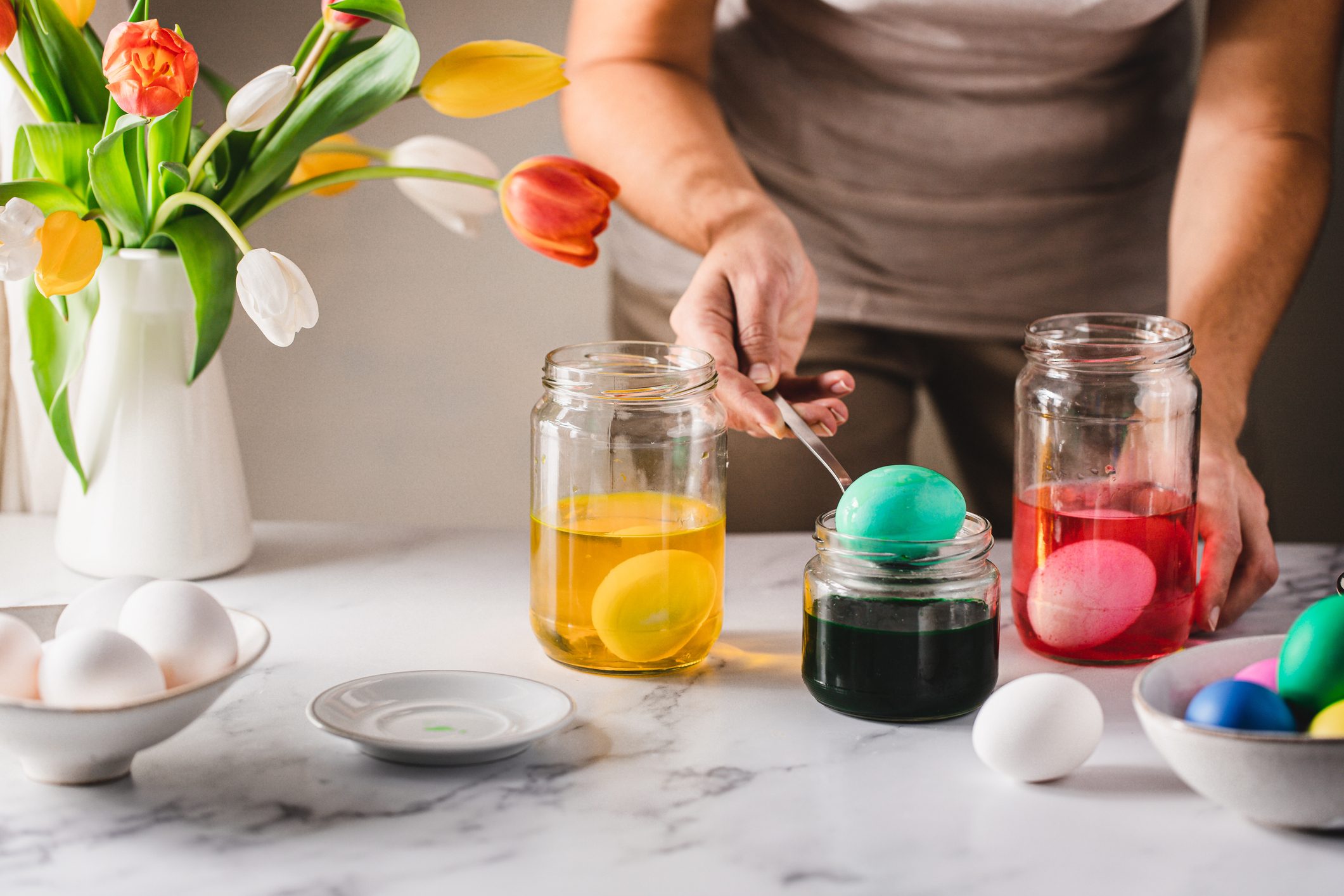 Woman dyeing Easter eggs at home