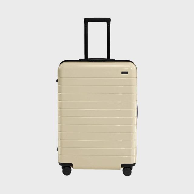 A beige rolling suitcase stands upright against a plain white background.