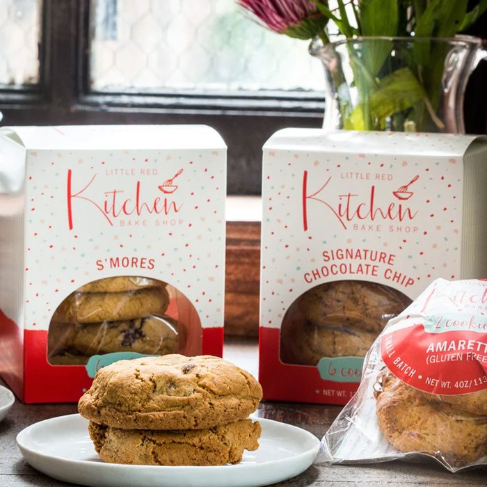 Cookies resting on a white plate, surrounded by packaged cookies labeled 