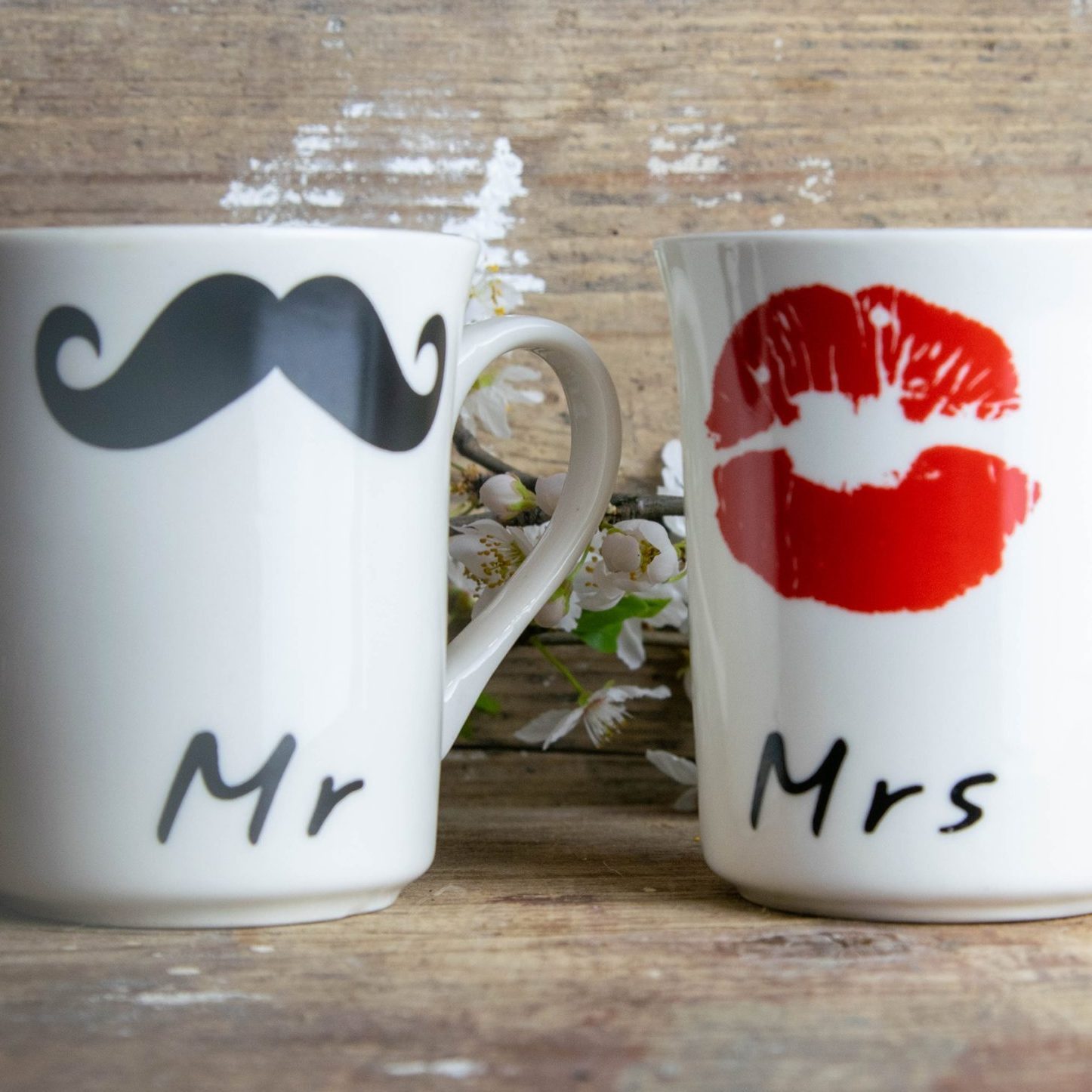 Two coffee cup with face of man and woman together with heart on wooden table. Concept of happy Valentines day
