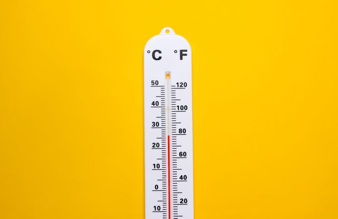 Weather thermometer on yellow background. Climate control. Top view
