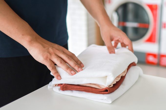 Man doing launder holding basket with dirty laundry of the washing machine in the public store. laundry clothes concept