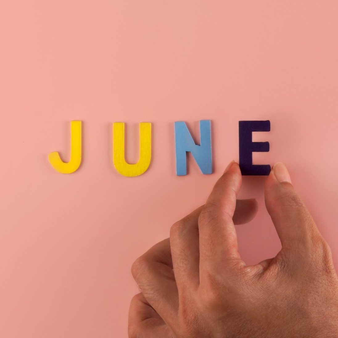 Hand holding , June word block in pink blackground